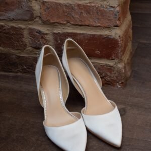 a pair of white shoes sitting on top of a wooden floor
